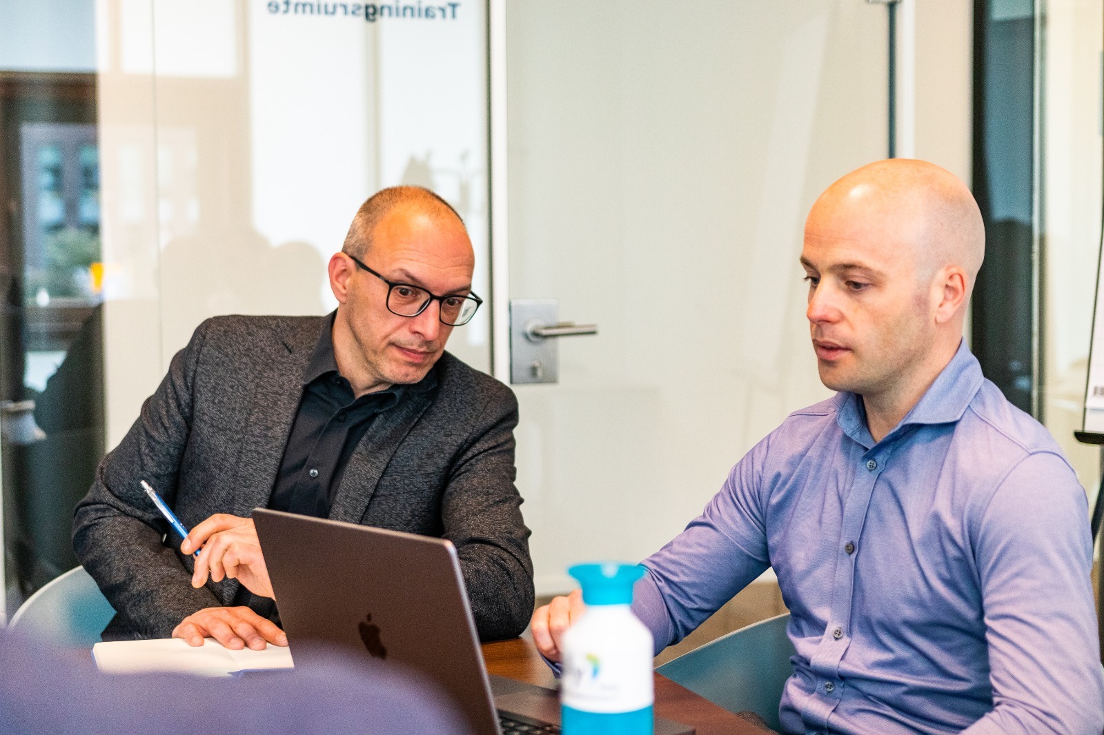 Zwei Mitglieder des Polly.Help-Teams arbeiten gemeinsam an einem Laptop